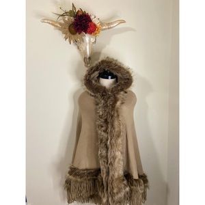 Tan fur lined cape with clasp in front.
